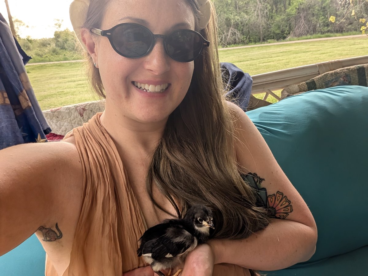 Casey holding a young chick during hands-on farm work